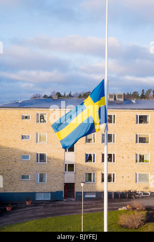 Bandiera svedese a mezz asta al di fuori di un edificio di appartamenti. Foto Stock