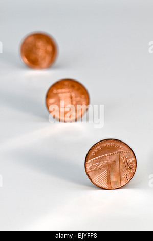 Tre un penny pezzi in linea diagonale contro uno sfondo bianco con la seconda e la terza delle monete in euro al di fuori della messa a fuoco Foto Stock