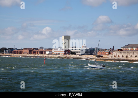 Piccolo yacht lasciando Portsmouth Porto sotto il motorino in mare mosso Foto Stock