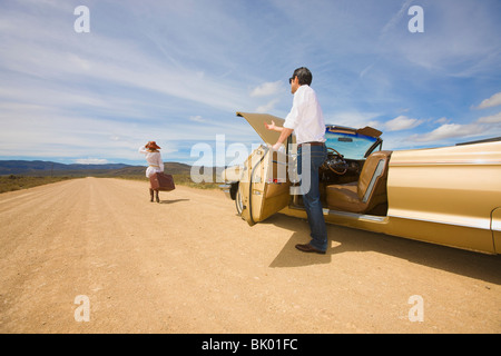 Giovane con problemi con la macchina nel deserto Foto Stock