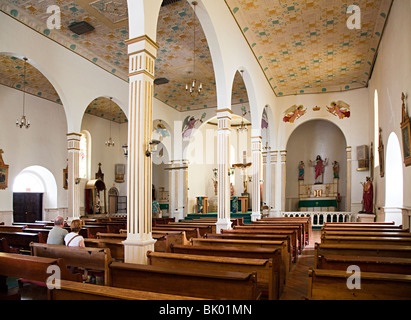 Due persone sedute in file di banchi in San Elizario Presidio Cappella El Paso Texas USA Foto Stock