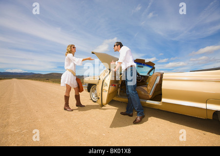 Giovane con problemi con la macchina nel deserto Foto Stock