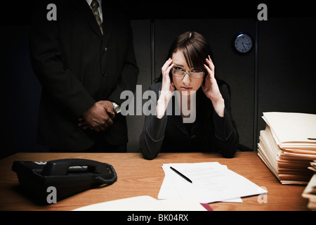 Boss dietro ha sottolineato la donna alla reception Foto Stock