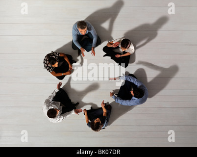 Uomini e donne seduti in cerchio Foto Stock