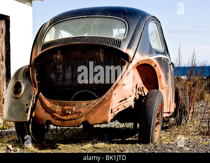 Vecchia auto arrugginita abbandonata sulla spiaggia Foto Stock