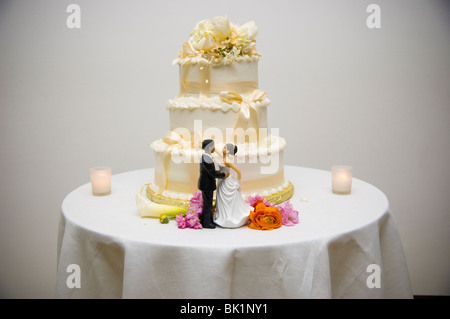 Bambole raffiguranti la sposa e lo sposo a stare di fronte ad una torta di nozze. Foto Stock