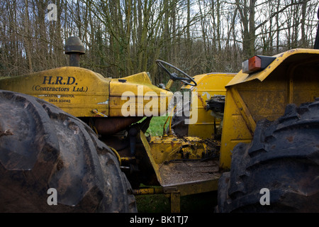 Registrazione di grandi dimensioni trattore con pneumatici giganti necessari per terreni accidentati giace ridondante nel bosco in prossimità di un smallholding in North Somerset. Foto Stock