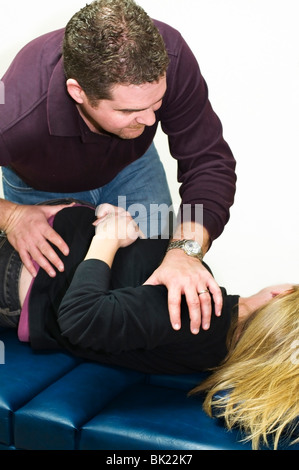 Un chiropratico regola il suo paziente femmina. Foto Stock