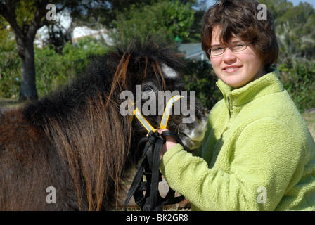 Ragazza Giovane (età 11), con pet Falabella cavalli in miniatura Foto Stock