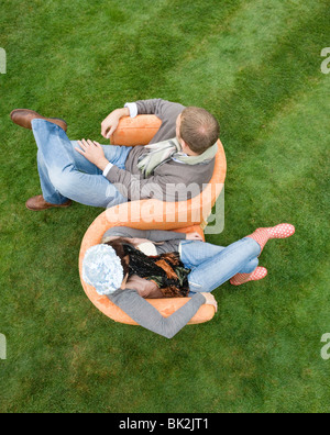 Giovane seduto sull'amore-sede all'aperto Foto Stock