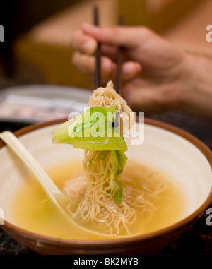 Uomo cinese di mangiare gamberetti e wonton noodle soup con bacchette al Chi Cafe in Chicago, IL Foto Stock