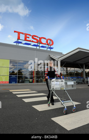 Donna shopper lasciando il supermercato Tesco a Ellesmere in nord Shropshire Regno Unito Foto Stock