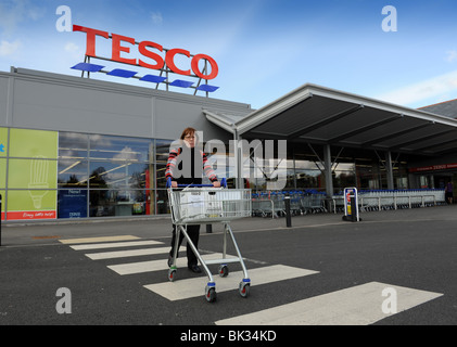 Donna shopper lasciando il supermercato Tesco a Ellesmere in nord Shropshire Regno Unito Foto Stock