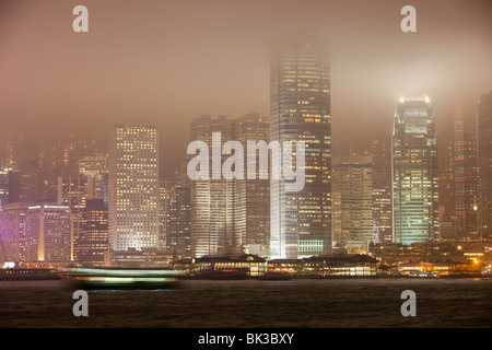 Ufficio blocchi illuminata di notte a Hong Kong, Cina. Questa popolosa città ha una massiccia impronta di carbonio. Foto Stock