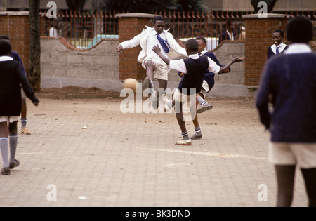 Scuola del Kenia bambini in divisa che giocano a calcio, Nairobi Foto Stock