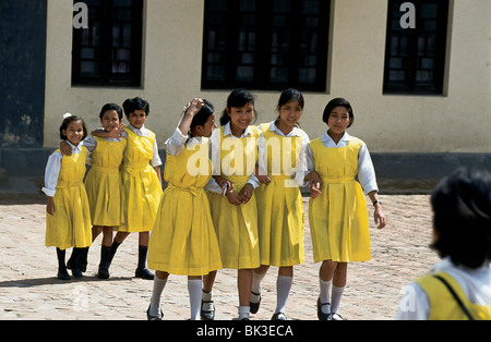 Bambini nepalesi che indossano abiti gialli e uniformi a Kathmandu, Nepal Foto Stock