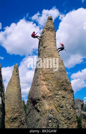 Due uomini rappelling da una guglia di roccia nella zona degli aghi nelle Black Hills del Sud Dakota. Foto Stock