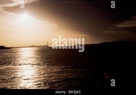Il sole e le nuvole parte anteriore sopra il fiume Orinoco con Angostura ponte di sospensione in background a Ciudad Bolivar, Venezuela Foto Stock
