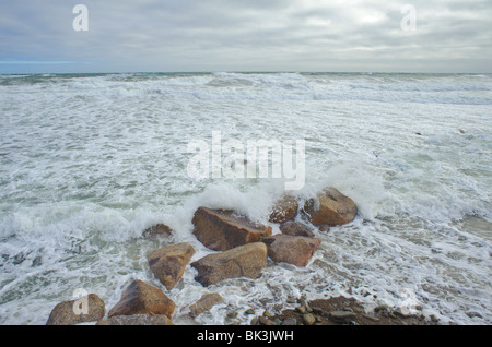 Isola Miscou rocce con onde che si infrangono all'alba dall'Oceano Atlantico Foto Stock