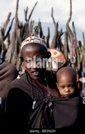 Ritratto di una donna Maasai che indossa una fascia con perline e tiene un bambino in Tanzania, Africa orientale Foto Stock