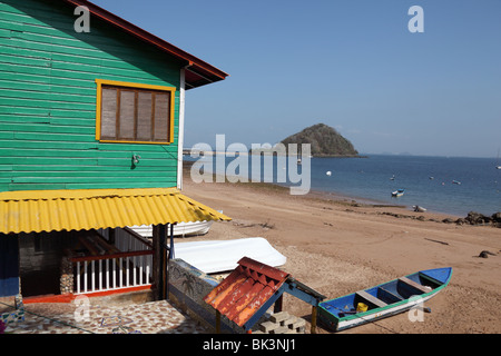 Casa di legno, barca da pesca e spiaggia Playa Honda, Isla El Morro in background, Taboga Island, Panama Foto Stock