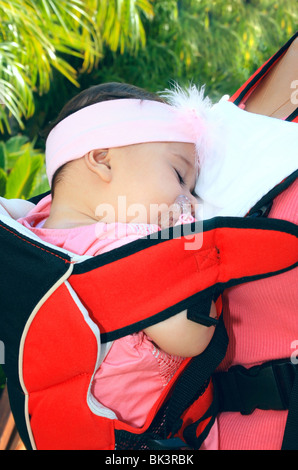 Sleeping Baby girl in uno zaino. Foto Stock