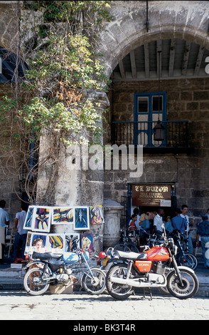 Motociclette, una mostra d'arte, e persone al di fuori del tele Correo Internacional, l'Avana, Cuba Foto Stock