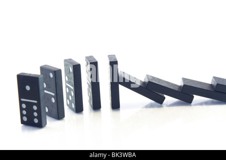 Catene di caduta di domino isolato su uno sfondo bianco Foto Stock