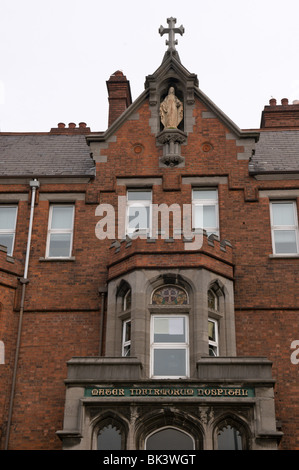 Ingresso anteriore del vecchio edificio presso la Mater Informorum Ospedale, Belfast, mostrando la statua della Vergine Maria e una croce Foto Stock