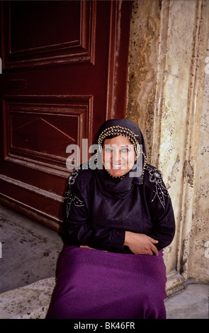 Ritratto di una donna sorridente seduto su una porta, Egitto Foto Stock