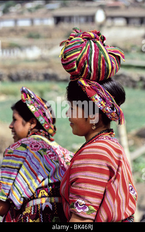 Ritratto di una donna maya che indossa abiti colorati e porta un pacchetto di mercato sulla sua testa vicino Cantel, Guatemala Foto Stock