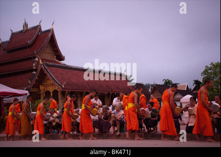 I monaci offrono riso all'alba, vicino al tempio di ami, Luang Prabang, Laos. Foto Stock