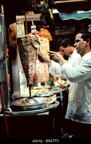 Venditore di kebab il taglio di carne a fette fuori un spiedo verticale ad Amman, Giordania Foto Stock