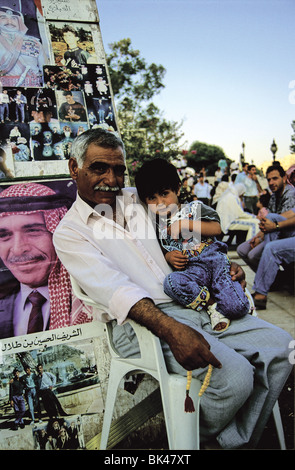 Ritratto di un uomo Giordano tenendo una bambina con un poster di Re Hussein di Giordania, 1991 Foto Stock