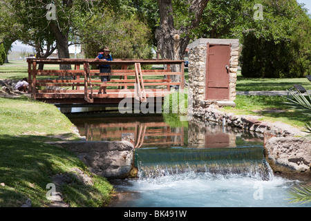 Persona in piedi sul ponte a stramazzo in canal alimentato da San molle Salomone Balmorhea parco dello stato Texas USA Foto Stock