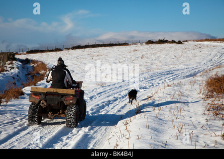 Agricoltore la guida su strade coperte di neve via in inverno Wales UK Foto Stock