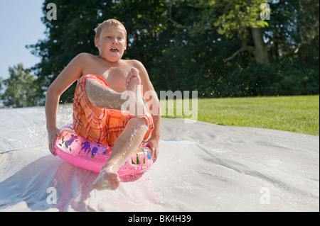 Ragazzo lo scorrimento verso il basso e di slittamento slitta Foto Stock