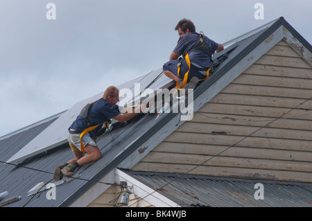 Operai di installare pannelli solari sul tetto a Hobart in Tasmania Australia Foto Stock