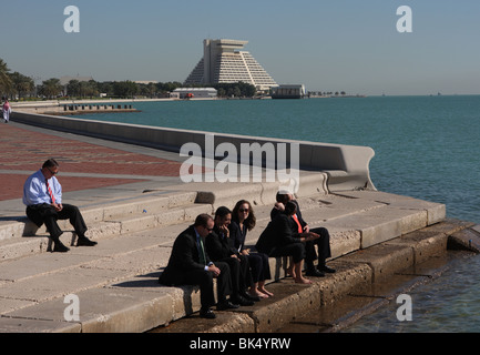 Un gruppo di dirigenti aziendali aventi la loro pausa pranzo sulla Corniche a Doha, in Qatar Foto Stock