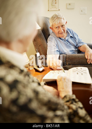 Coppia di anziani in casa di riposo lavorando su Cruciverba Foto Stock