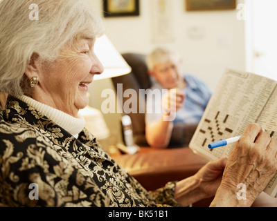 Coppia di anziani in casa di riposo, donna che lavorano su Cruciverba Foto Stock