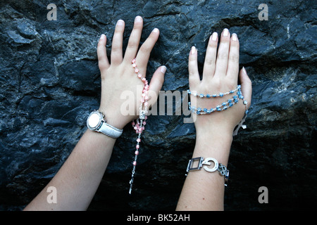 Pellegrini di toccare la grotta di Lourdes, Lourdes Hautes Pirenei, Francia, Europa Foto Stock