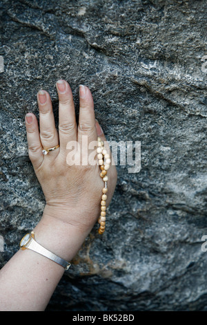 Pellegrino di toccare la grotta di Lourdes, Lourdes Hautes Pirenei, Francia, Europa Foto Stock