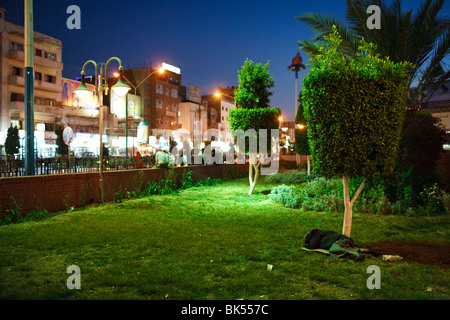 Un uomo dorme sotto un albero a Piazza Tahrir, Sana'a, Yemen Foto Stock