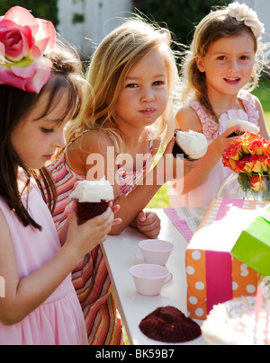 Le ragazze di mangiare i tortini a una festa di compleanno Foto Stock
