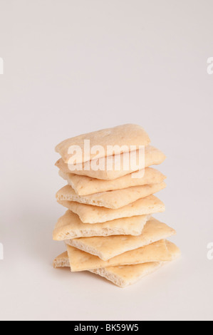 Close-up di frumento organico cracker impilati in alto sulla cima di ogni altro su sfondo bianco Foto Stock