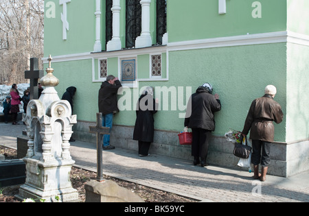 I credenti di persone che pregano, avendo appoggiato contro i muri della chiesa in Russia, San Pietroburgo. Il giorno di Pasqua Foto Stock