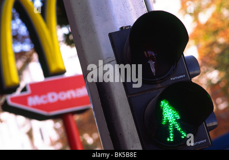 Semaforo verde dà o a piedi segnale in corrispondenza di un attraversamento pedonale a Sofia, Bulgaria. Un McDonalds segno è in background. Foto Stock