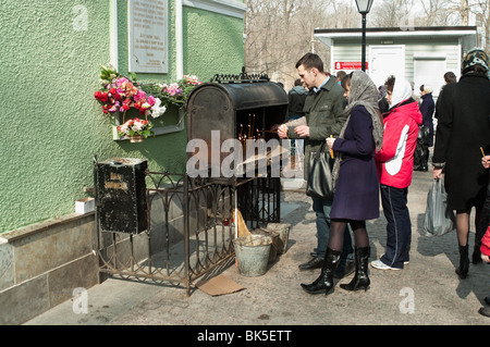 Popolo credente messo candele sulla Chiesa in Russia, San Pietroburgo. Il giorno di Pasqua Foto Stock