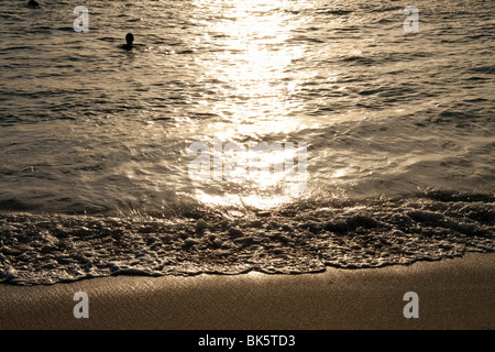 Onda di mare sulla spiaggia tropicale di Flic en Flac al tramonto sulla costa occidentale dell'isola di Mauritius. Foto Stock